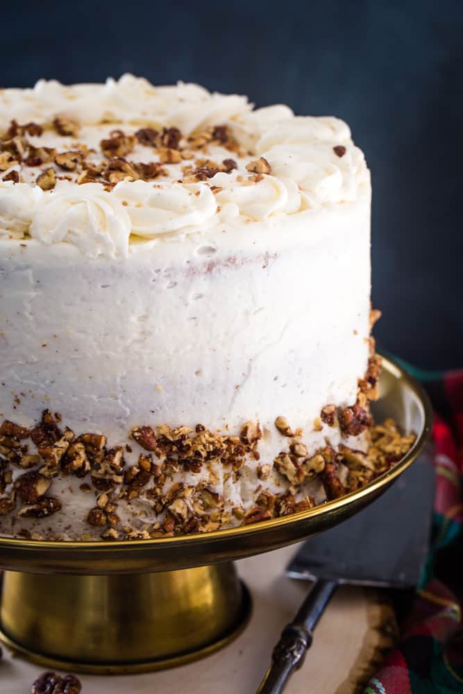 eggnog layer cake with candied pecans on gold cake plate