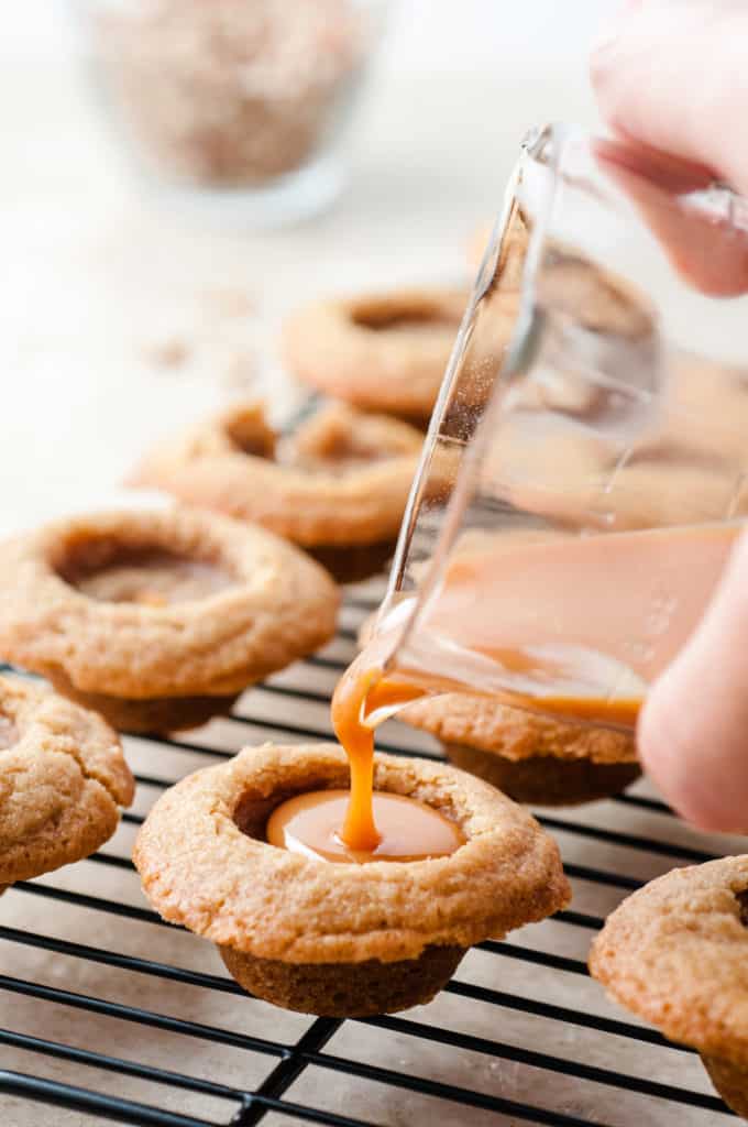 pouring the caramel into the cookie cups
