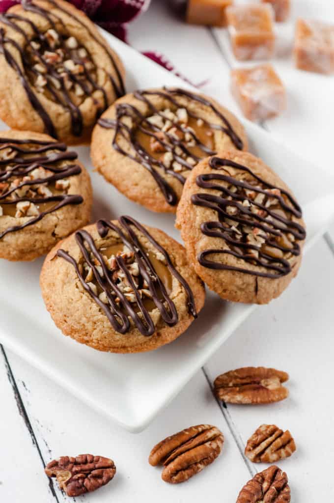 white plate of caramel pecan cookie cups with pecans