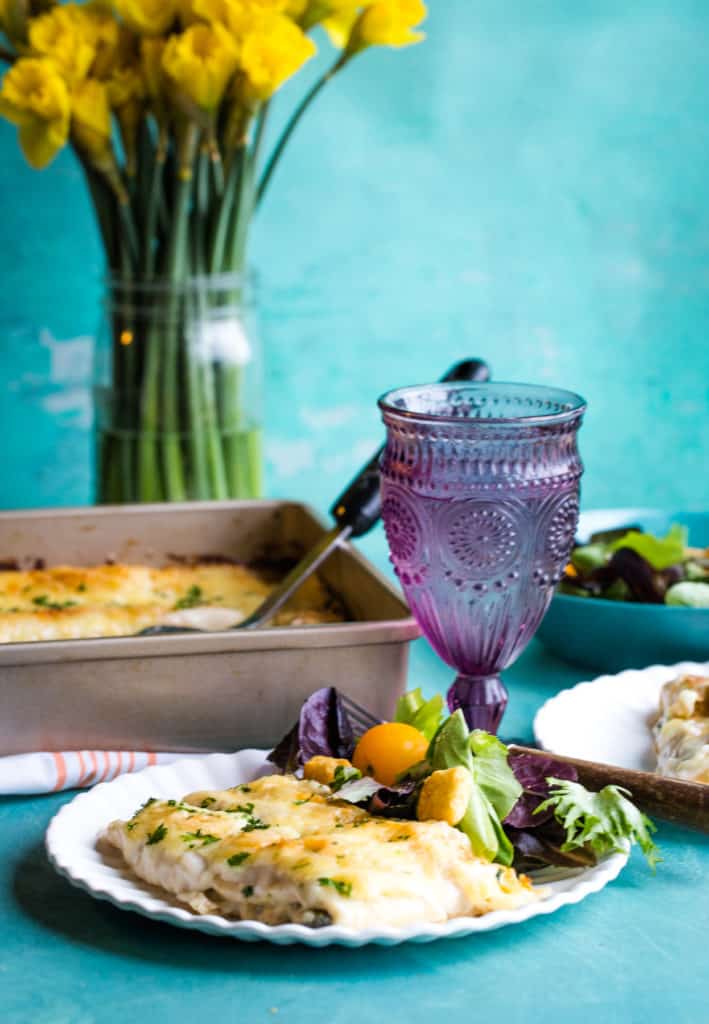 plate of broccoli chicken stuffed crepes on white plate with purple cup