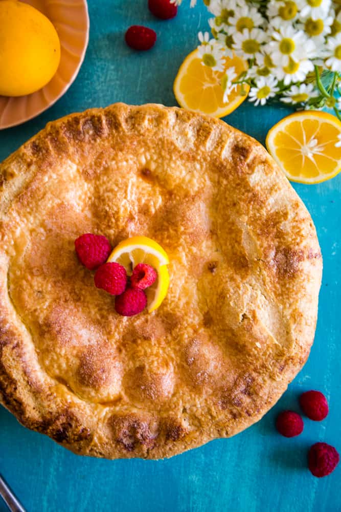 whole pie with raspberries and lemon slice on top