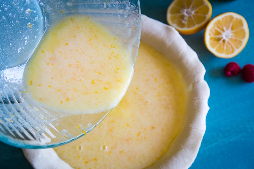 pouring the lemon filling into the pie crust