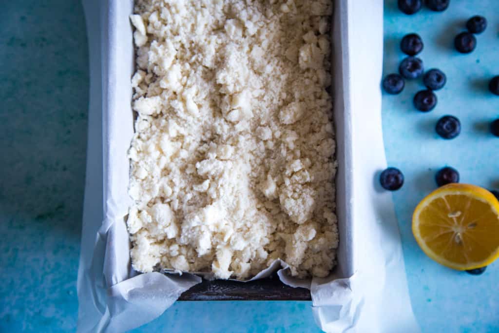 parchment lined pan with lemon blueberry bread batter