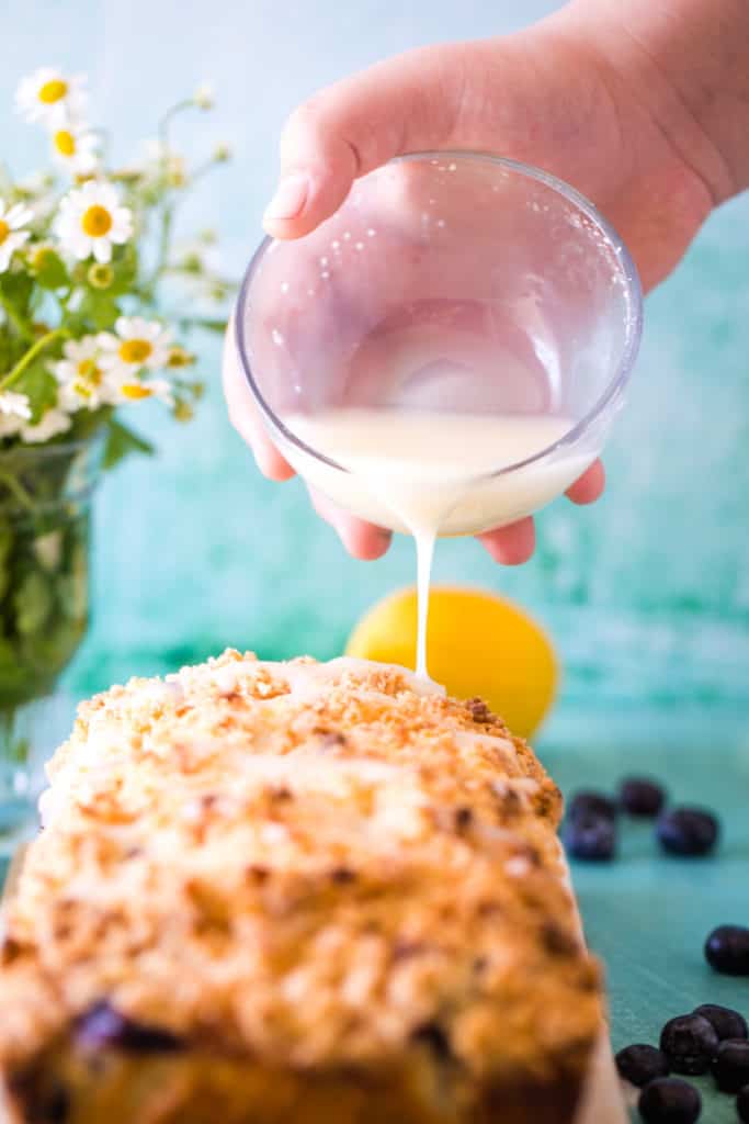 hand pour lemon glaze over blueberry bread