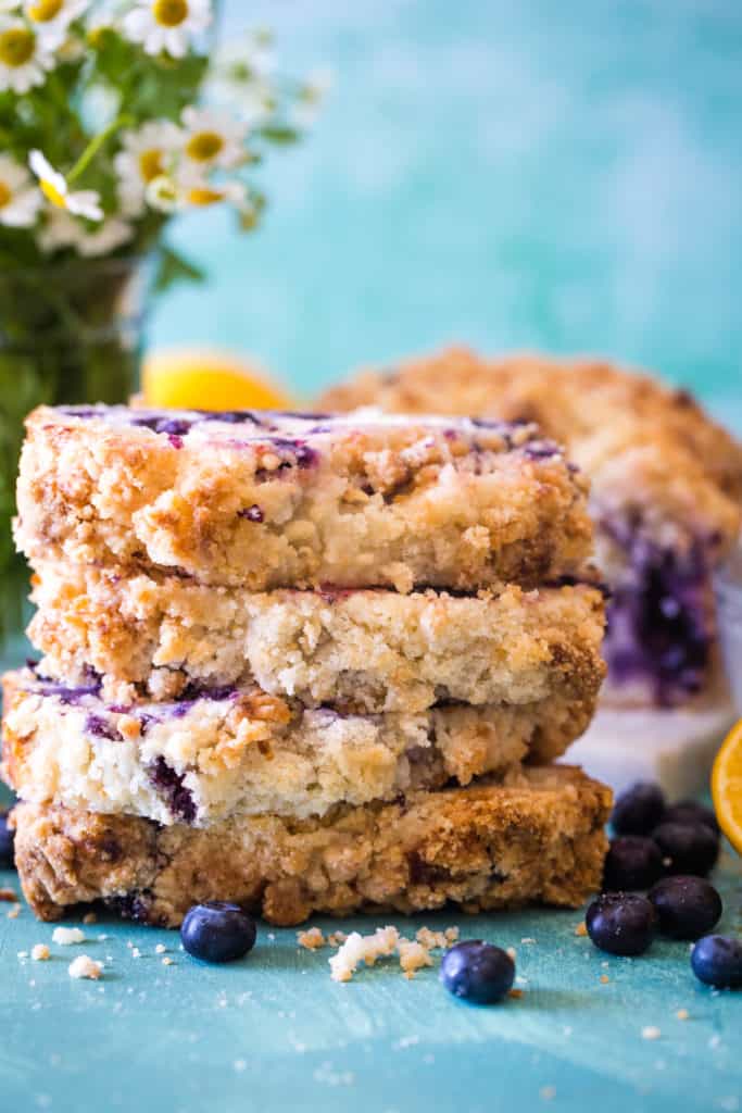 stacked slices of lemon blueberry bread on teal background