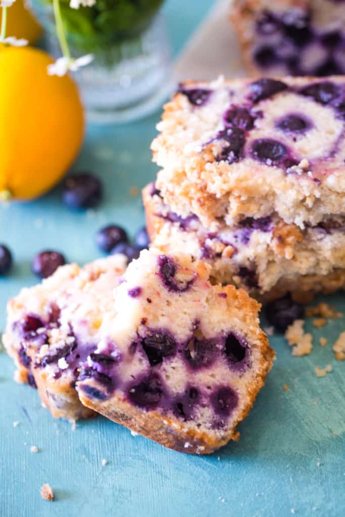 slices of blueberry bread on teal background