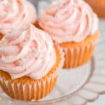 three cupcakes with pink frosting on pink cake plate