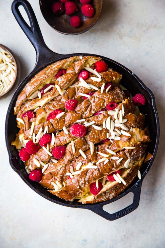 cast iron pan with unbaked raspberry almond french toast