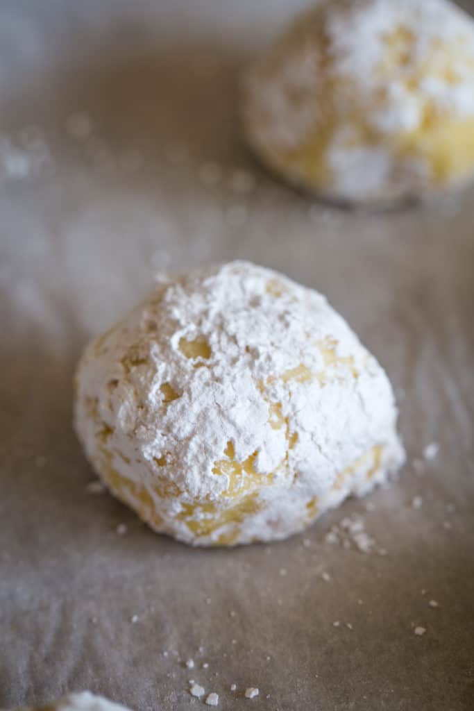 lemon bar cookie dough ball with powdered sugar coating before baking