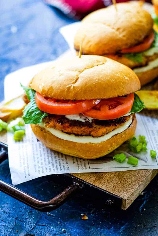 two salmon burgers in wood plank