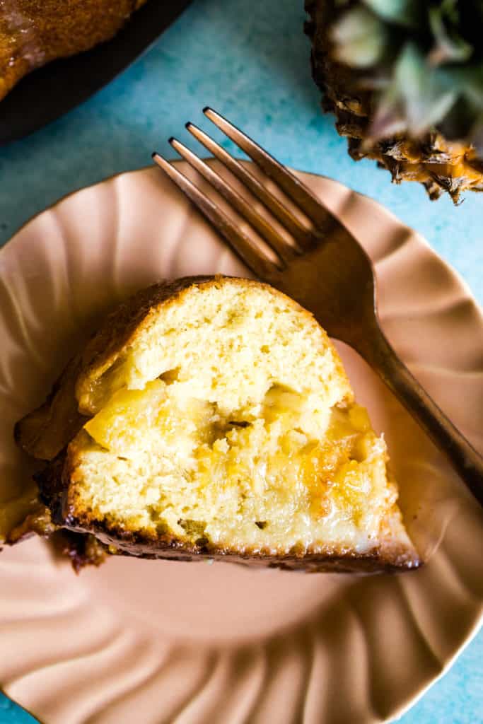 slice of upside down pineapple bundt cake on pink plate