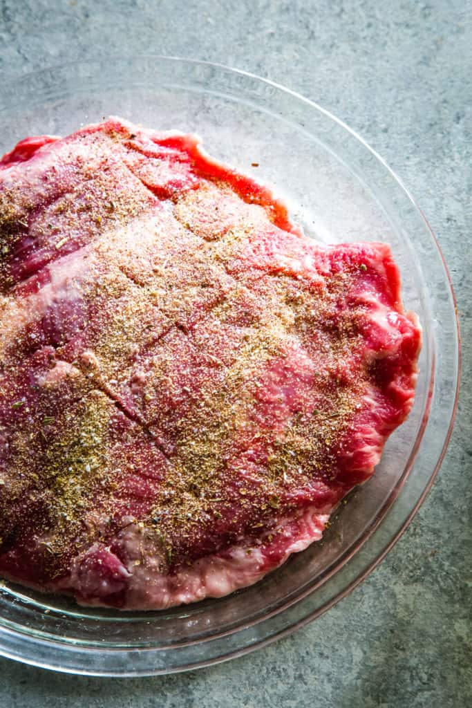 raw flank steak with herbs and spices