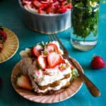 square of strawberry french toast tiramisu on peach plate with blue background