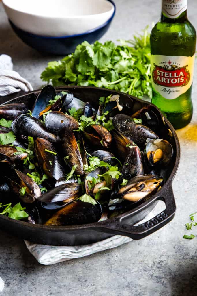 skillet with steamed cilantro beer broth mussels