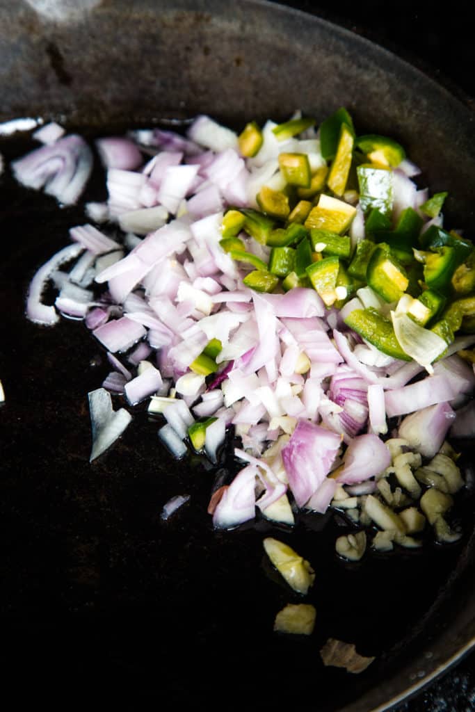 shallots and jalapenos cooking in skillet