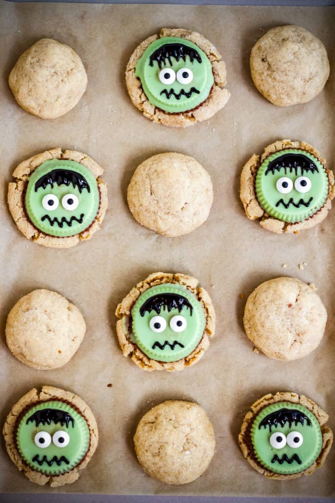 frankenstein peanut butter cookies on a parchment lined baking sheet