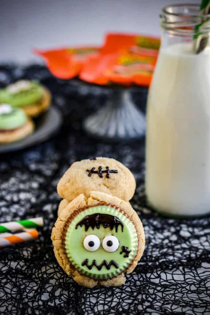 frankenstein peanut butter cookie next to a glass of milk