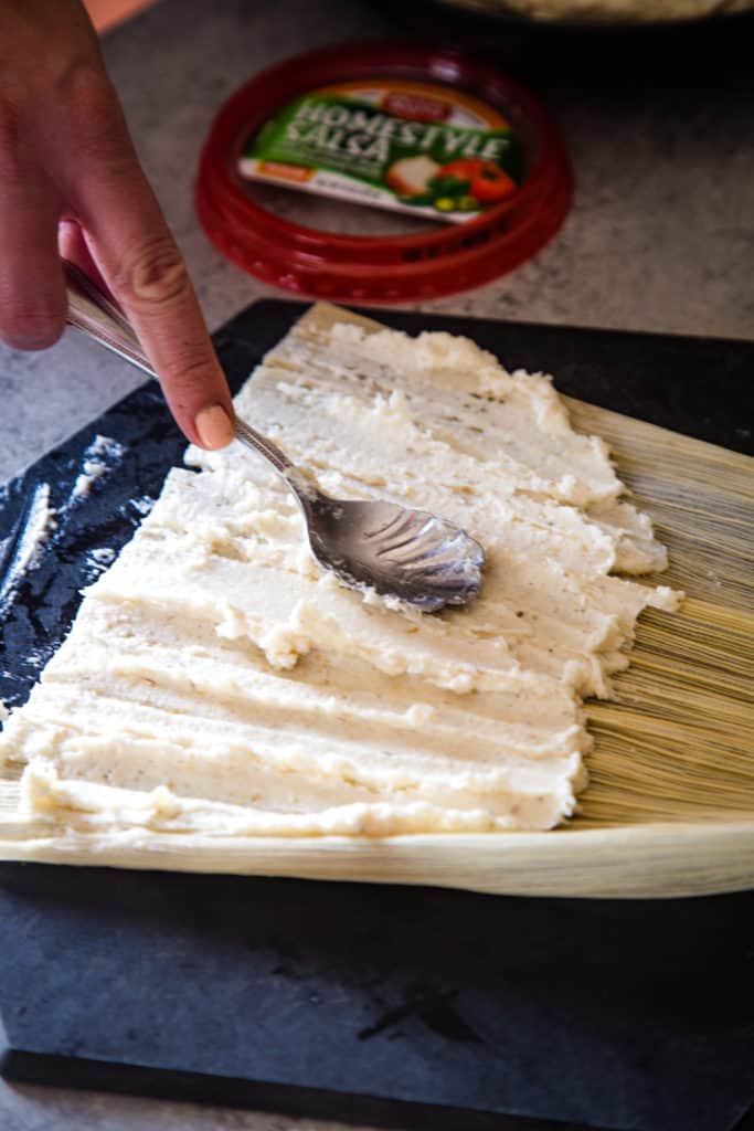 spreading the masa on the corn husk