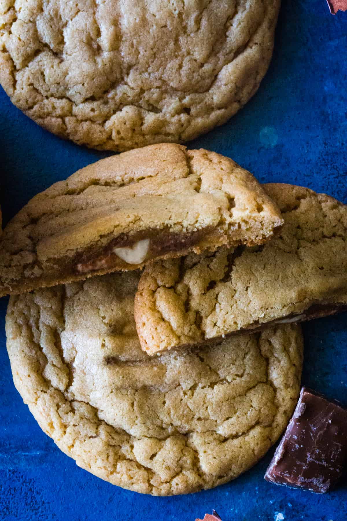 Up close shot of a cookie cut in half showing the snickers center. 