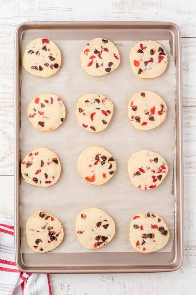 cookie sheet lined with parchment paper with dark chocolate cherry shortbread cookies. 