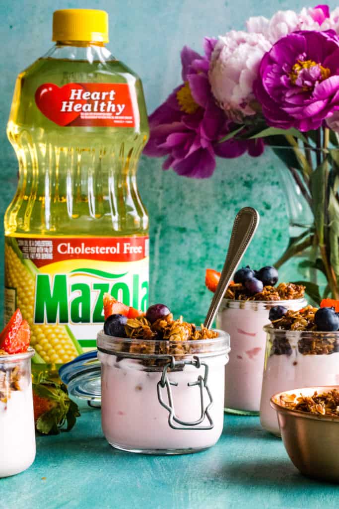 yogurt jars with granola and bottle of oil in background