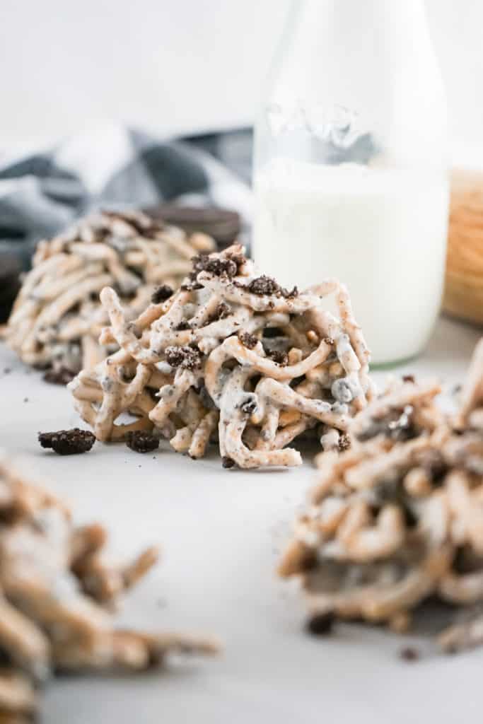 cookies and cream cookie haystacks on white background with glass of milk