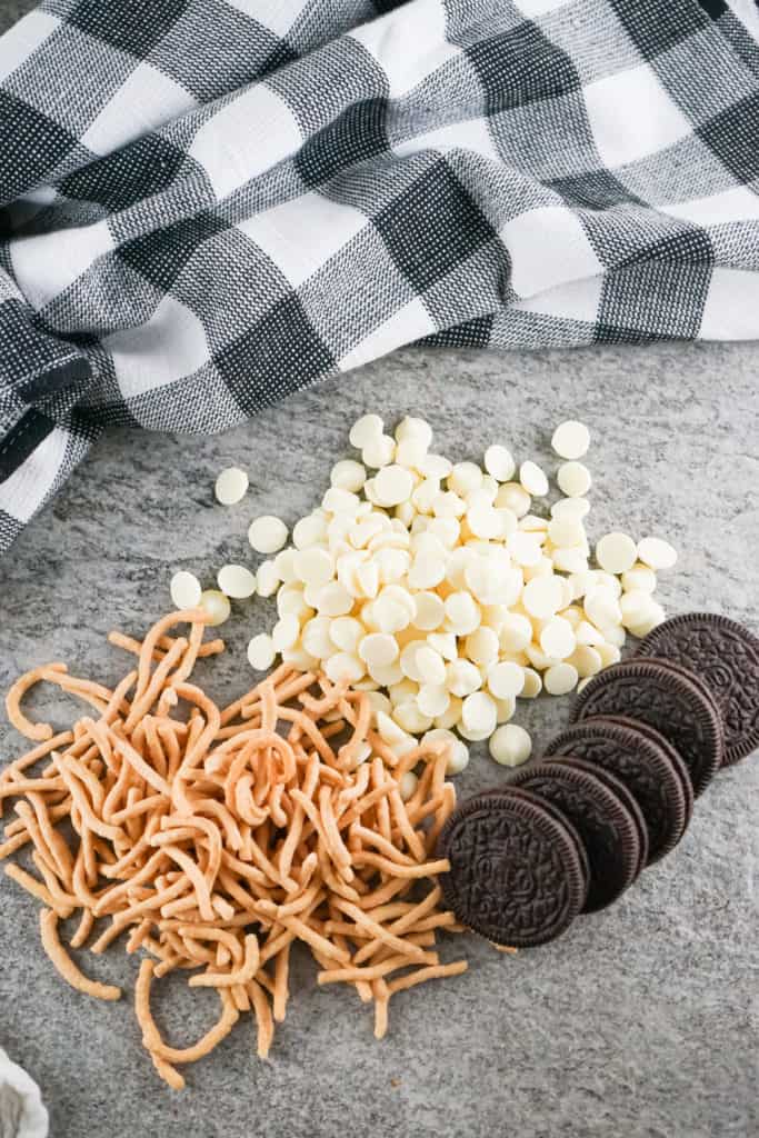 ingredients to make haystacks on metal background with black and white dish towel. 