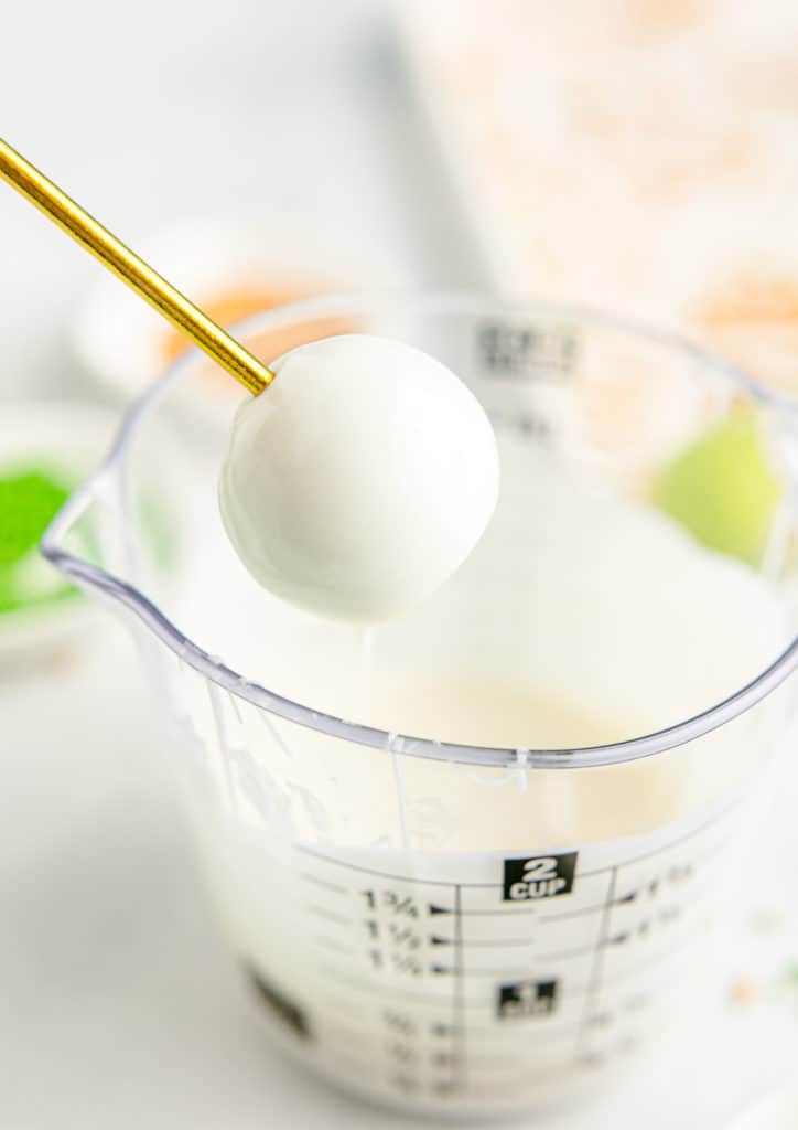 removing the green cake pops from white chocolate dipping