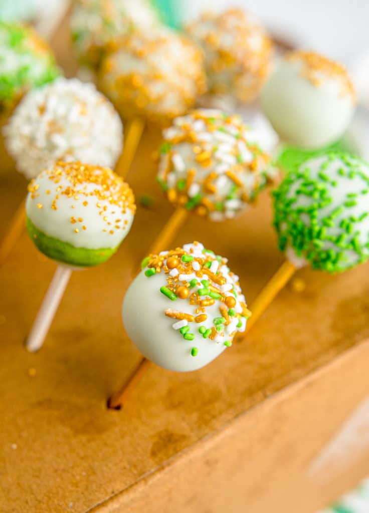 green cake pops in wooden holder