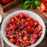 marinated tomato onion salad in white bowl