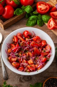 marinated tomato onion salad in white bowl