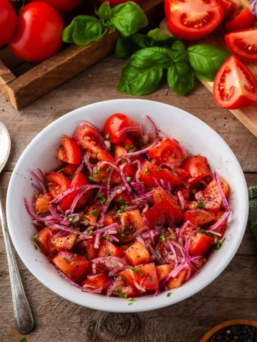marinated tomato onion salad in white bowl