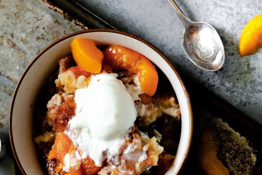 Bowl of peach cobbler with ice cream