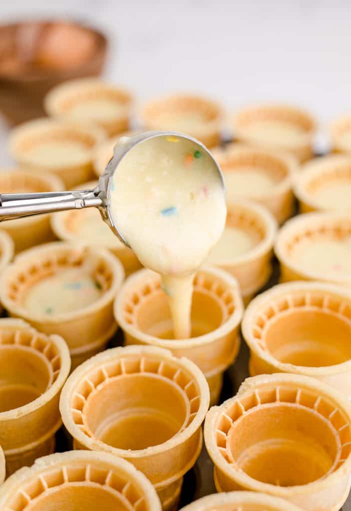 filling the ice cream cones with cupcake batter