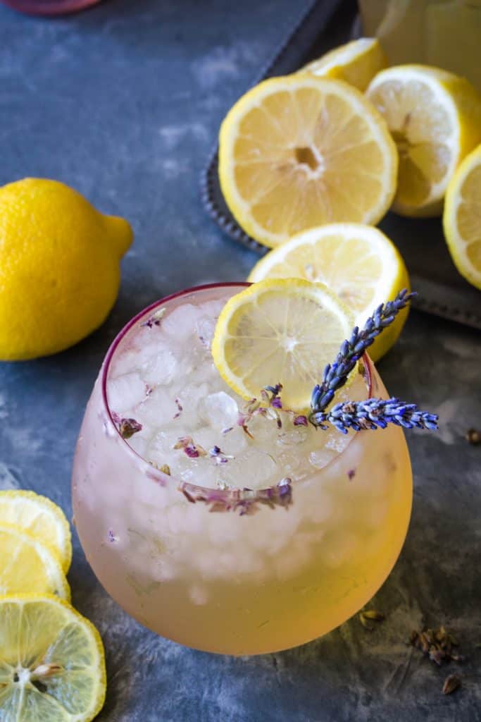 pink glass of lavender lemonade with lemon slices and fresh lavender