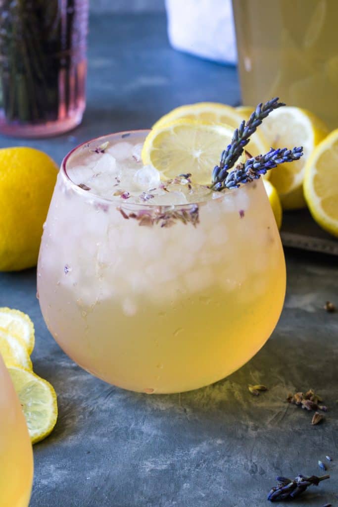 glass filled with ice and lavender lemonade on a metal background