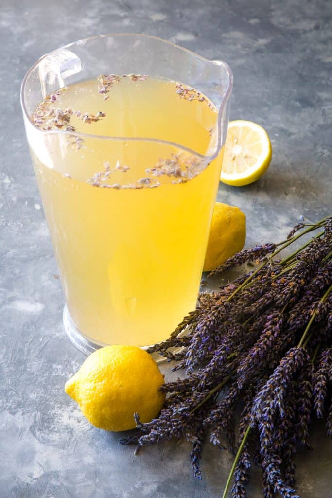 a large pitcher of lavender lemonade on a metal background