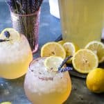 two glasses of lavender lemonade with bouquet of fresh lavender in background