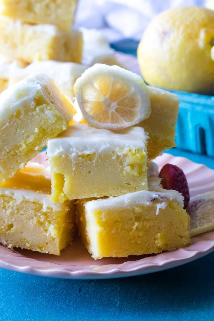 close up of lemon bars on pink plate