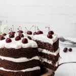 hand taking a slice of Black Forest cake on white background