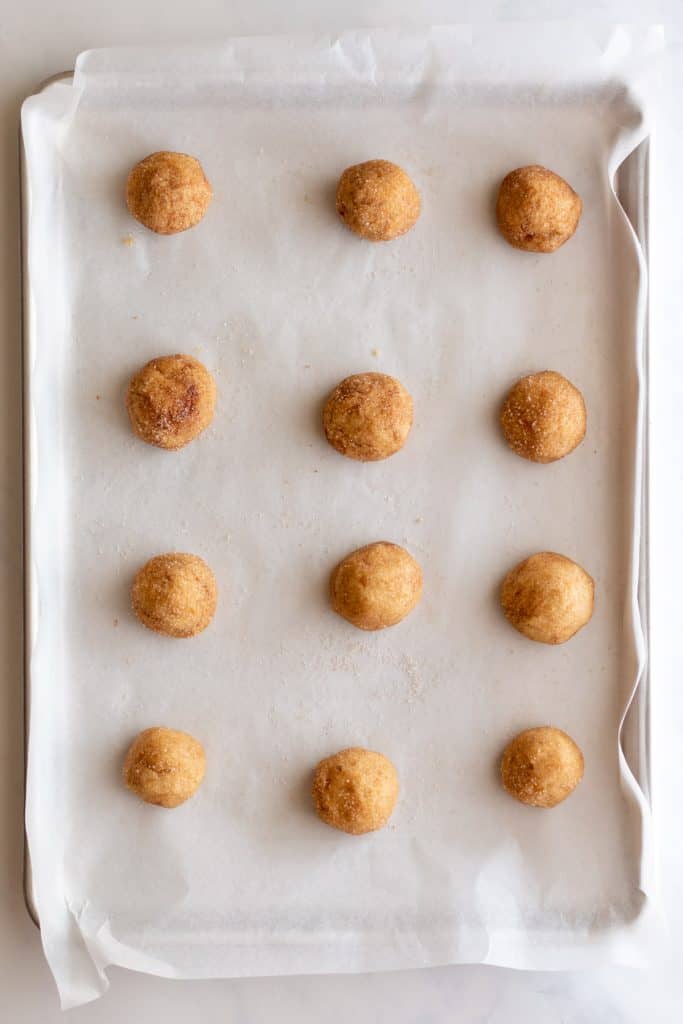 snickerdoodle dough balls on lined pan