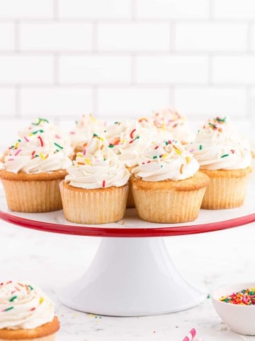 white cake plate with white cupcakes