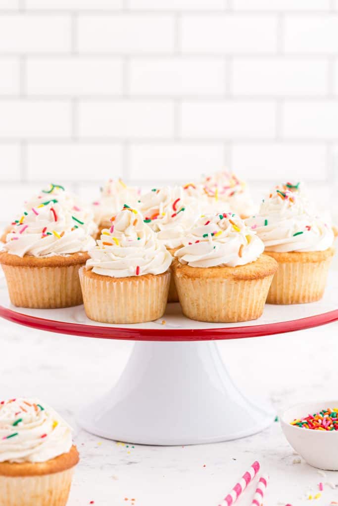 white cake plate with white cupcakes