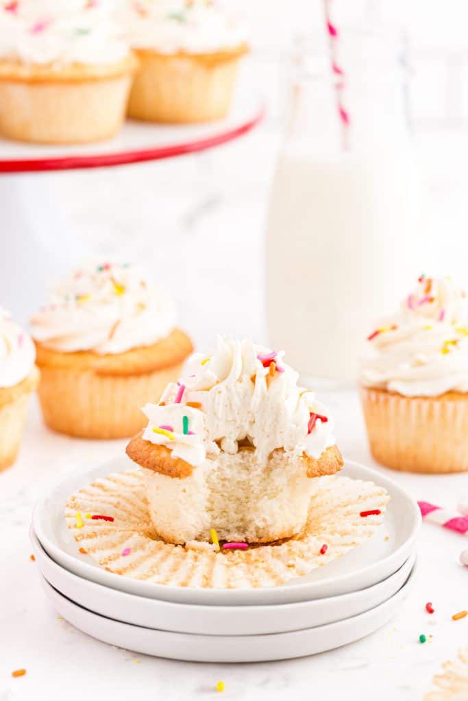 white plates with white cupcake that has a bite out of it