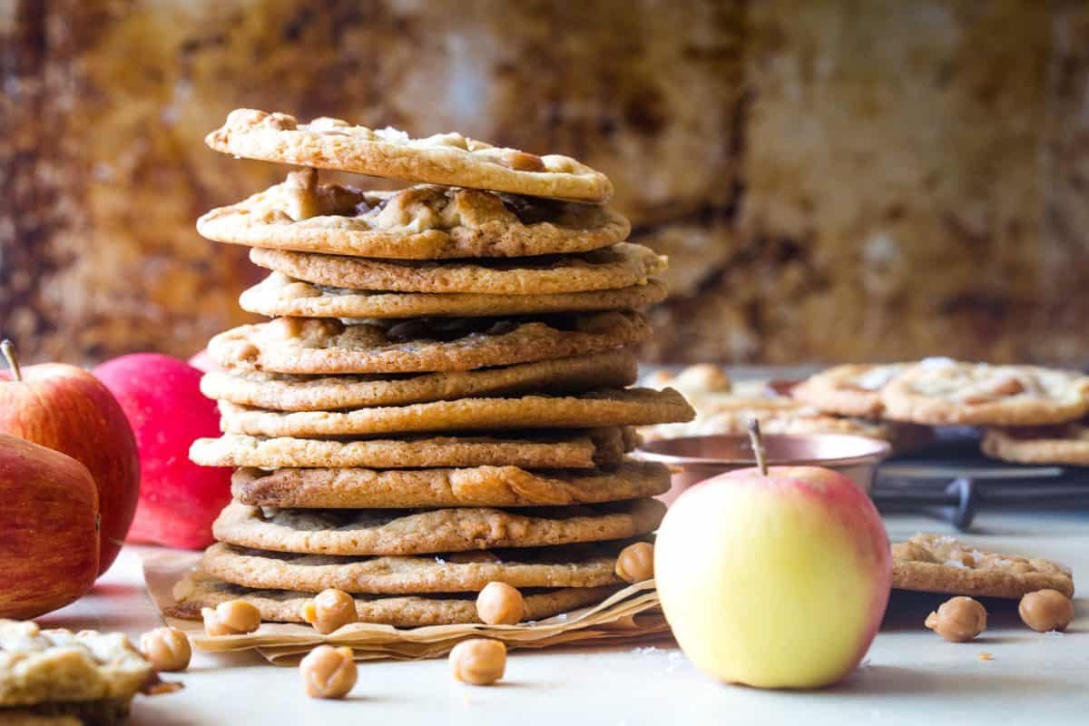 vertical shot of the cookies in a large stack with apples around them. 