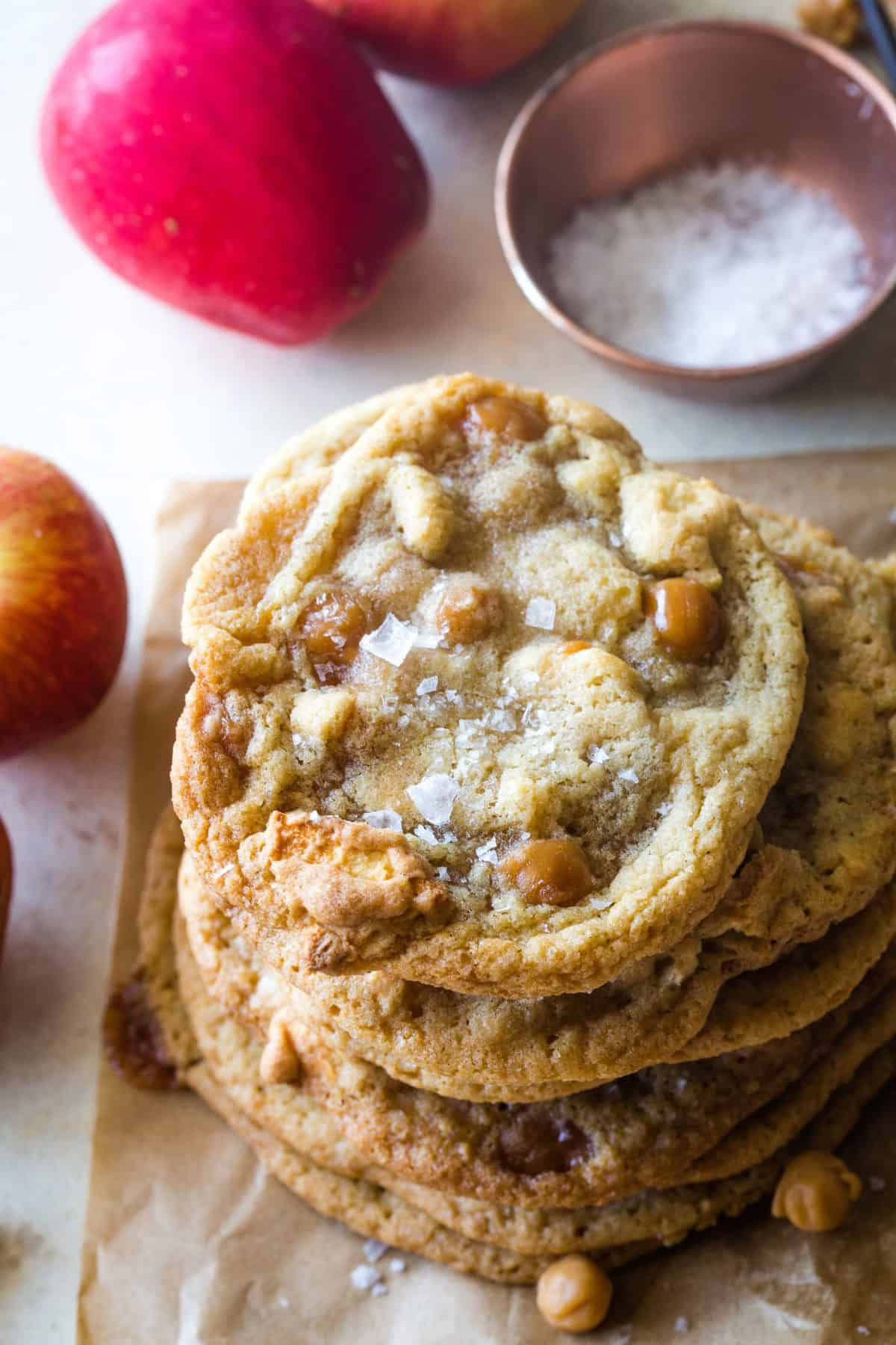 Over head shot of the stacked cookies with small bowl of salt and apple in the background. 