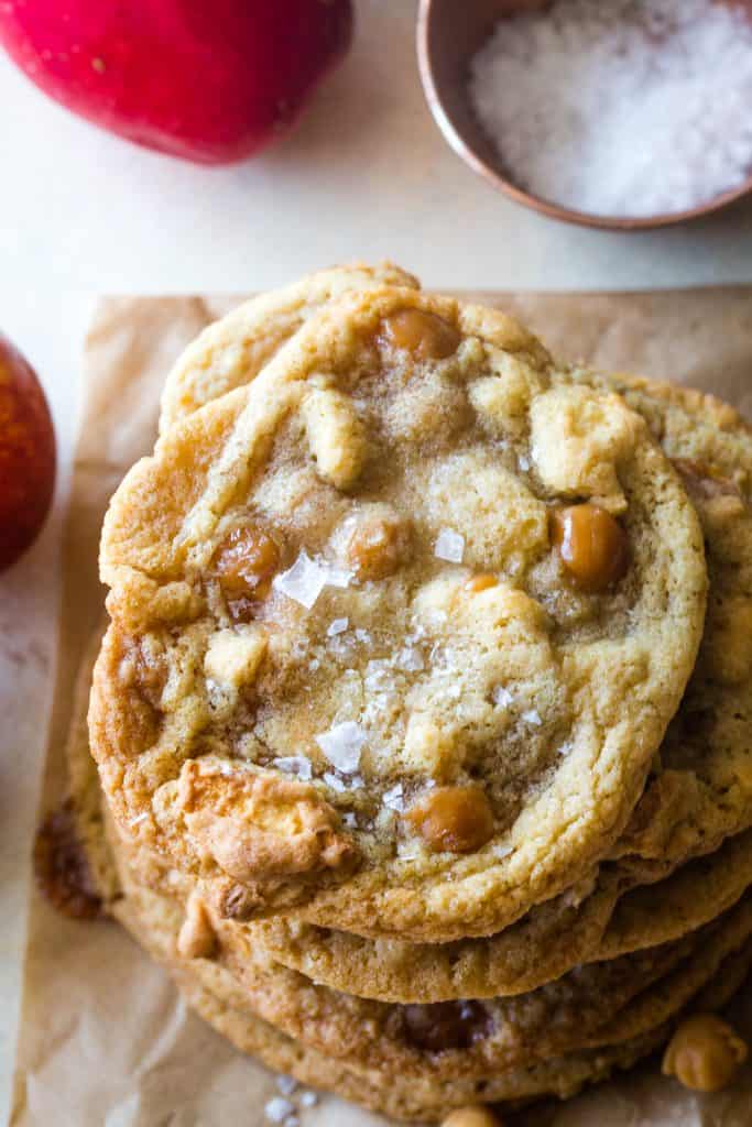 stacked caramel apple cookies with bowl of salt