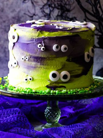 halloween monster eye cake on green cake plate with neon green sprinkles.