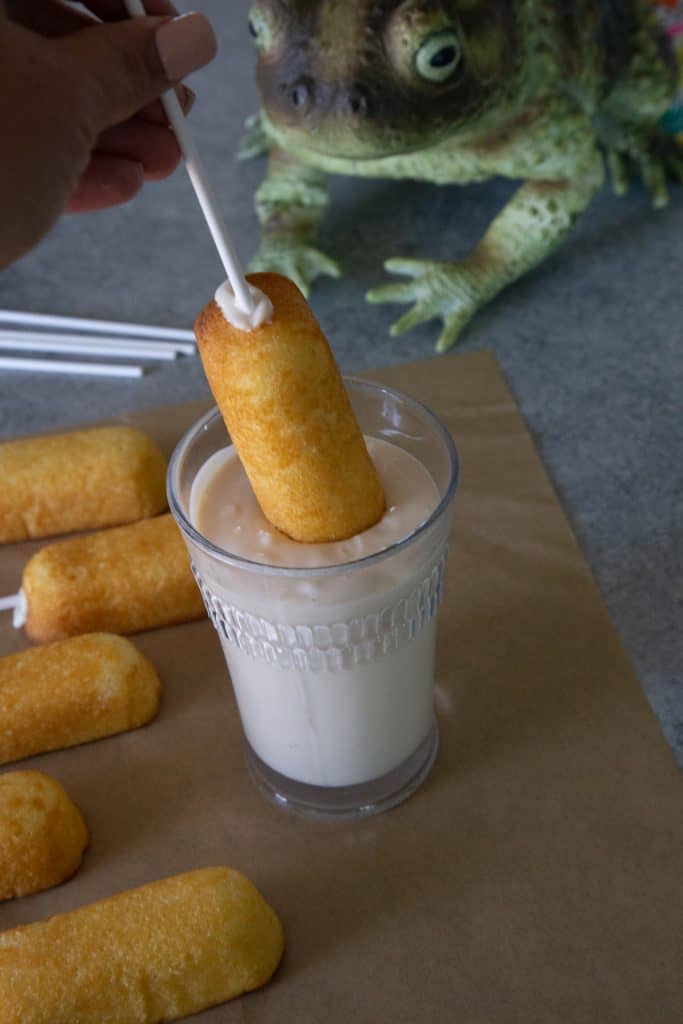 dipping the Twinkie into the cup of melted white chocolate