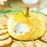 pumpkin shaped cheese ball on wood cutting board